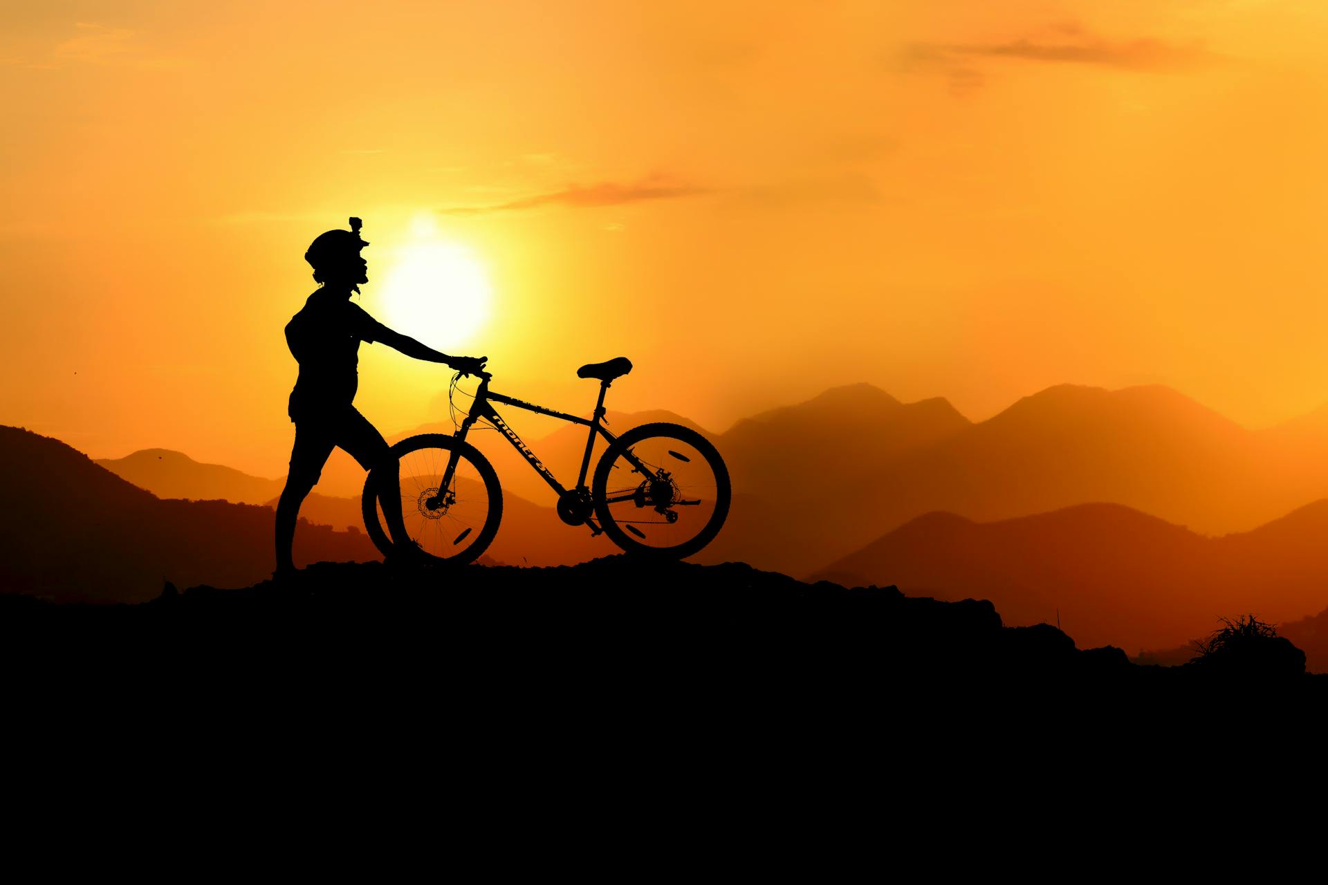 A cyclist on a hilltop at sunrise